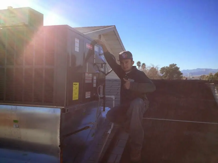 HVAC technician performing Heat Pump Repair on a rooftop unit in Stonegate